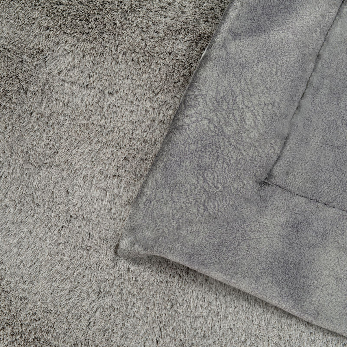 Detailaufnahme der zwei Seiten der grauen Hundedecke Hyggeplaid mit flauschigem Winter-Webpelz und glatterer Sommerseite